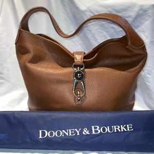 Dooney & Bourke shoulder bag. Brown in color with large brass clasp.